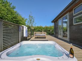 An outdoor area with a hot tub and champagne at 7 Valley View in Lanreath