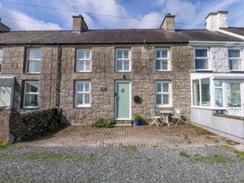 A house with a green door and a small patio area at Bryn Tirion in Moelfre