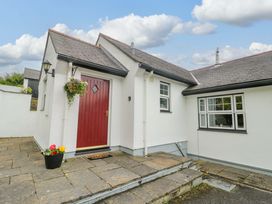 A house entrance with a red door and flower pots at Bwthyn Clai in Llangefni