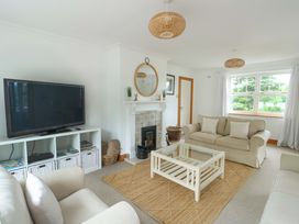 A living room with a television and sofa at Bwthyn Clai in Llangefni