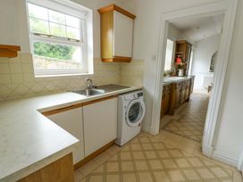 A kitchen with a sink and washing machine at Bwthyn Clai in Llangefni