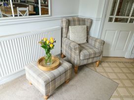 A living room with an armchair and ottoman in Bwthyn Clai Llangefni