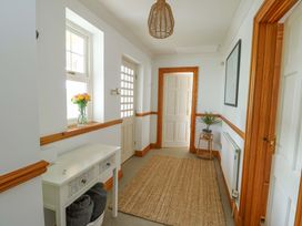 A hallway with a console table and rug at Bwthyn Clai in Llangefni