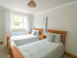 A bedroom with two beds and a window at Bwthyn Clai in Llangefni