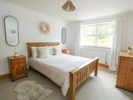 A bedroom with a bed and bedside tables at Bwthyn Clai in Llangefni