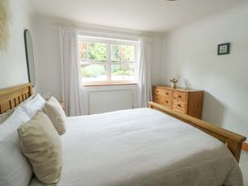 A bedroom with a bed and dresser at Bwthyn Clai in Llangefni
