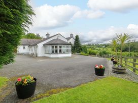 A house with driveway and flower pots at Bwthyn Clai in Llangefni