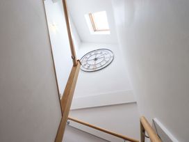 A staircase with a clock and skylight at Mallard Cottage Penrith