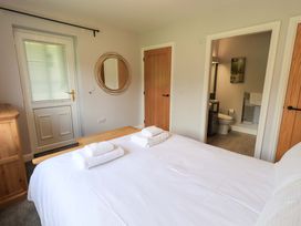 A bedroom with a bed and access to a bathroom at Mallard Cottage in Penrith