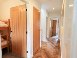 A hallway with wooden doors and a bunk bed at Mallard Cottage in Penrith