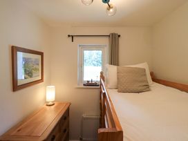 A bedroom with a bed and lamp at Mallard Cottage in Penrith