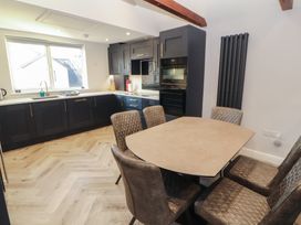A kitchen with a table and chairs at Mallard Cottage in Penrith