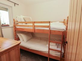A bedroom with a bunk bed and chest of drawers at Mallard Cottage in Penrith