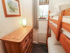 A bedroom with a bunk bed and dresser at Mallard Cottage in Penrith