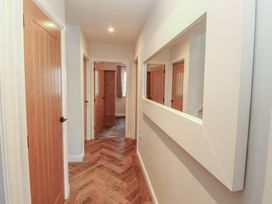 A hallway with doors and a mirror at Mallard Cottage in Penrith