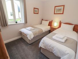 A bedroom with two single beds and a bedside table at Mallard Cottage in Penrith