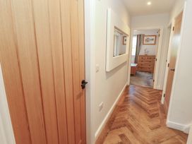 A hallway with a door and a mirror at Mallard Cottage Penrith
