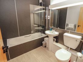 A bathroom with a bathtub, toilet, and sink at Mallard Cottage in Penrith