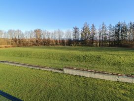 A grassy area with trees in the background at Mallard Cottage Penrith