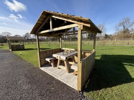 A wooden shelter with a table and benches at No Deer Ashbourne