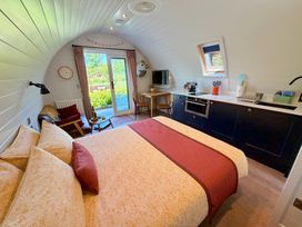 A bedroom with a kitchen area and dining table at No Deer in Ashbourne