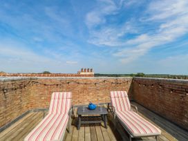 A roof terrace with deck chairs and a table at Skylark in Southwold