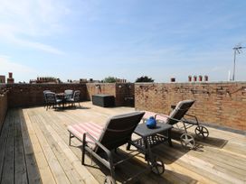 A roof terrace with deck chairs and a dining table at Skylark in Southwold