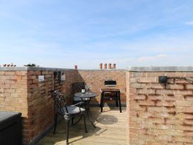 A terrace with a table and chairs at Skylark in Southwold