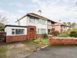 A semi detached house with a driveway and garden in a residential area at The Hollies in Prestatyn