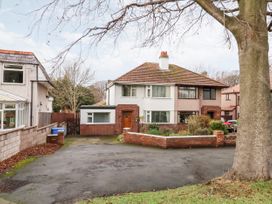 A semi detached house with a driveway and garden in front at The Hollies in Prestatyn