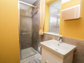 A bathroom with a shower enclosure sink window with blinds and a mirror cabinet at The Hollies in Prestatyn