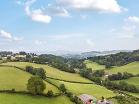 A countryside view with fields and hills at Barcud Coch - Red Kite in Garthmyl