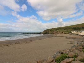 A beach with ocean and hills at 7 Beachdown Challaborough