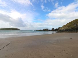 A beach with water and hills at 7 Beachdown, Challaborough