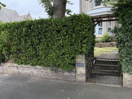 A garden with a hedge and a gate at The Furness Haven in Barrow-In-Furness