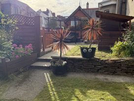 A garden with flower bed, paving stones, and plants at The Furness Haven in Barrow-In-Furness