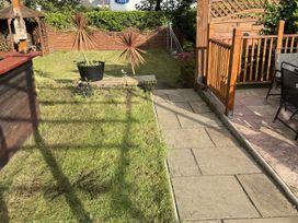 A garden with a pathway and wooden decking at The Furness Haven in Barrow-In-Furness