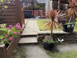 A garden with flowers and potted plants at The Furness Haven in Barrow-In-Furness