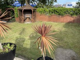 A garden with a wooden pavilion and seating at The Furness Haven in Barrow-In-Furness