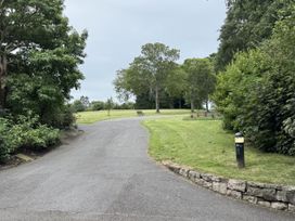A pathway leading to a bench surrounded by trees and grass at The Furness Haven in Barrow-In-Furness