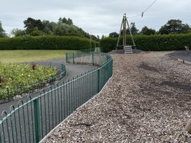 A playground area with a slide and a flower bed at The Furness Haven Barrow-In-Furness