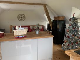 A kitchen with a refrigerator and a Christmas tree at Coach House, Clawdd-Newydd
