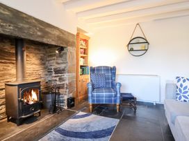A living room with a fireplace and armchair at Ael Y Bryn in Ffestiniog