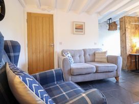 A living room with a sofa and armchair at Ael Y Bryn in Ffestiniog