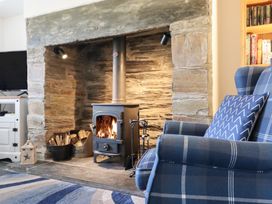A living room with a fireplace and a chair at Ael Y Bryn Ffestiniog