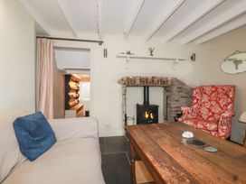 A living room with a fireplace and seating area at Penvar in Truro