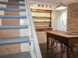 A kitchen with stairs and wooden table at Penvar in Truro