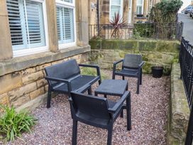 An outdoor seating area with black chairs and a table at Rose House in Alnmouth
