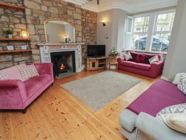 A living room with a fireplace and sofas at Rose House in Alnmouth
