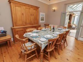 A dining room with a table set for eight at Rose House in Alnmouth